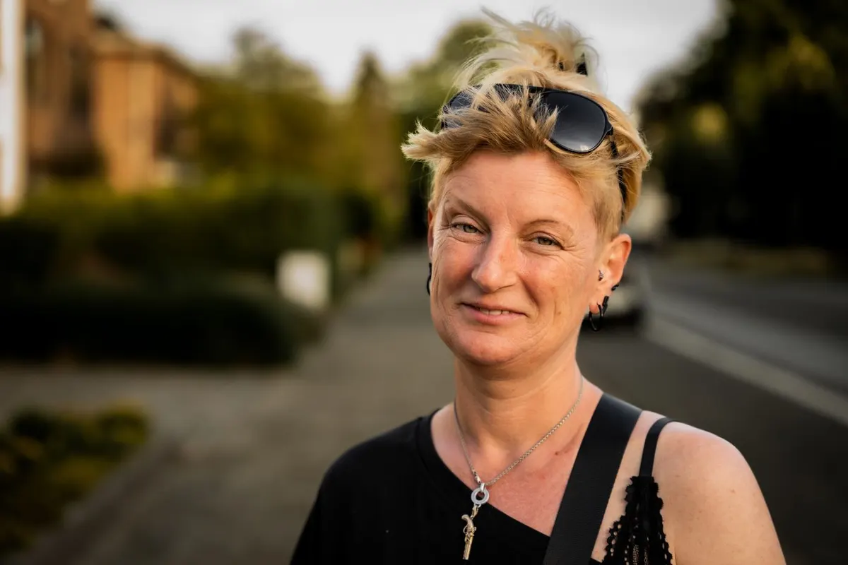 A woman in her forties outdoors, calm and confident