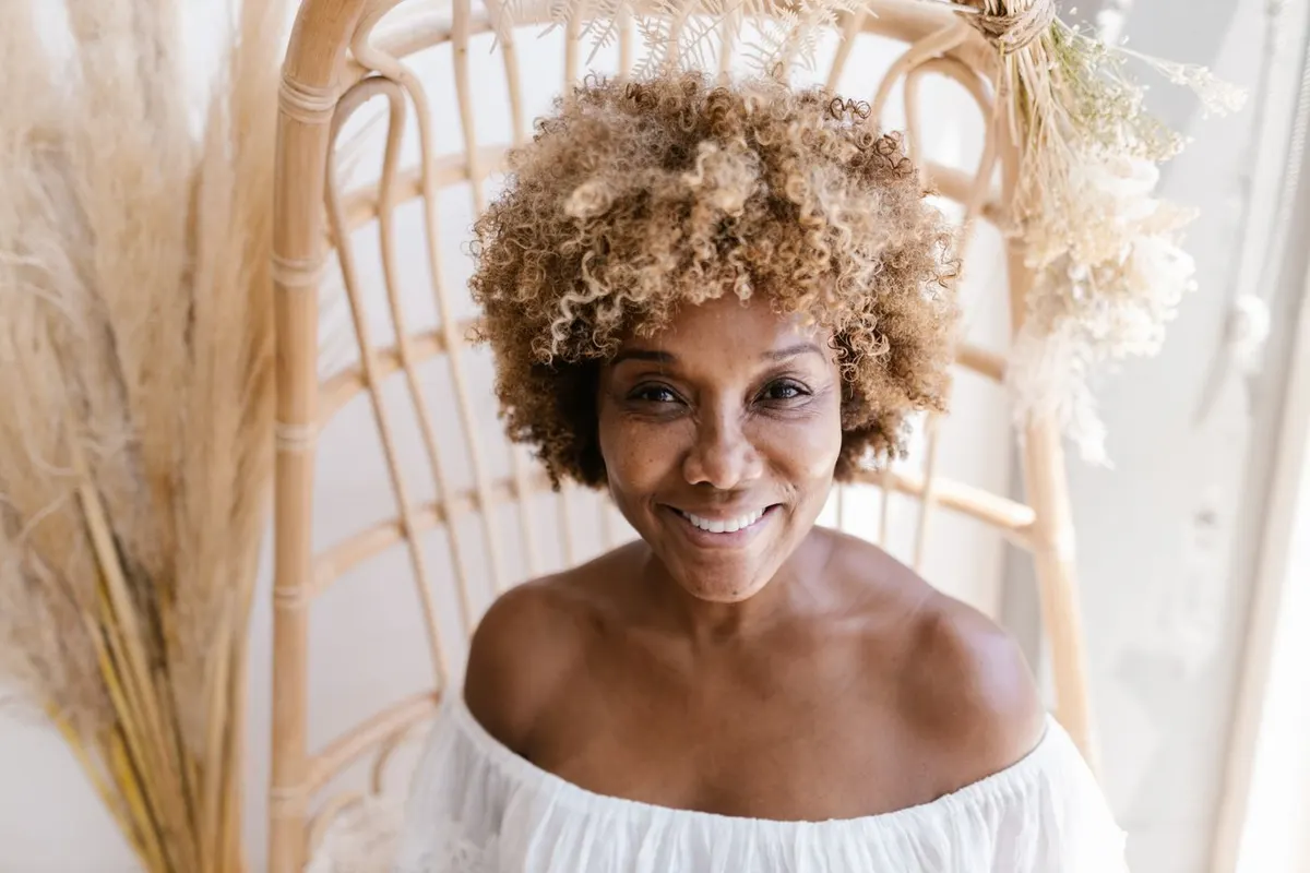 A woman in her forties with a warm smile, relaxed at home