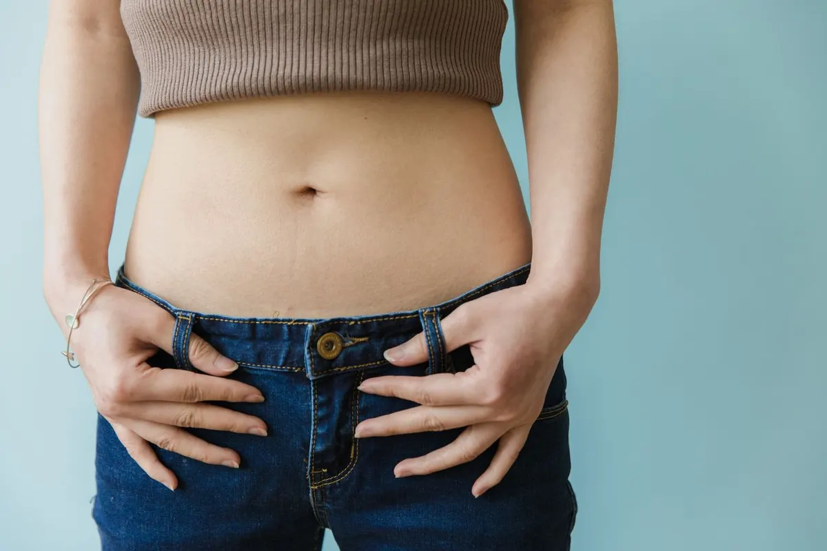 A woman with her hands resting on her midsection