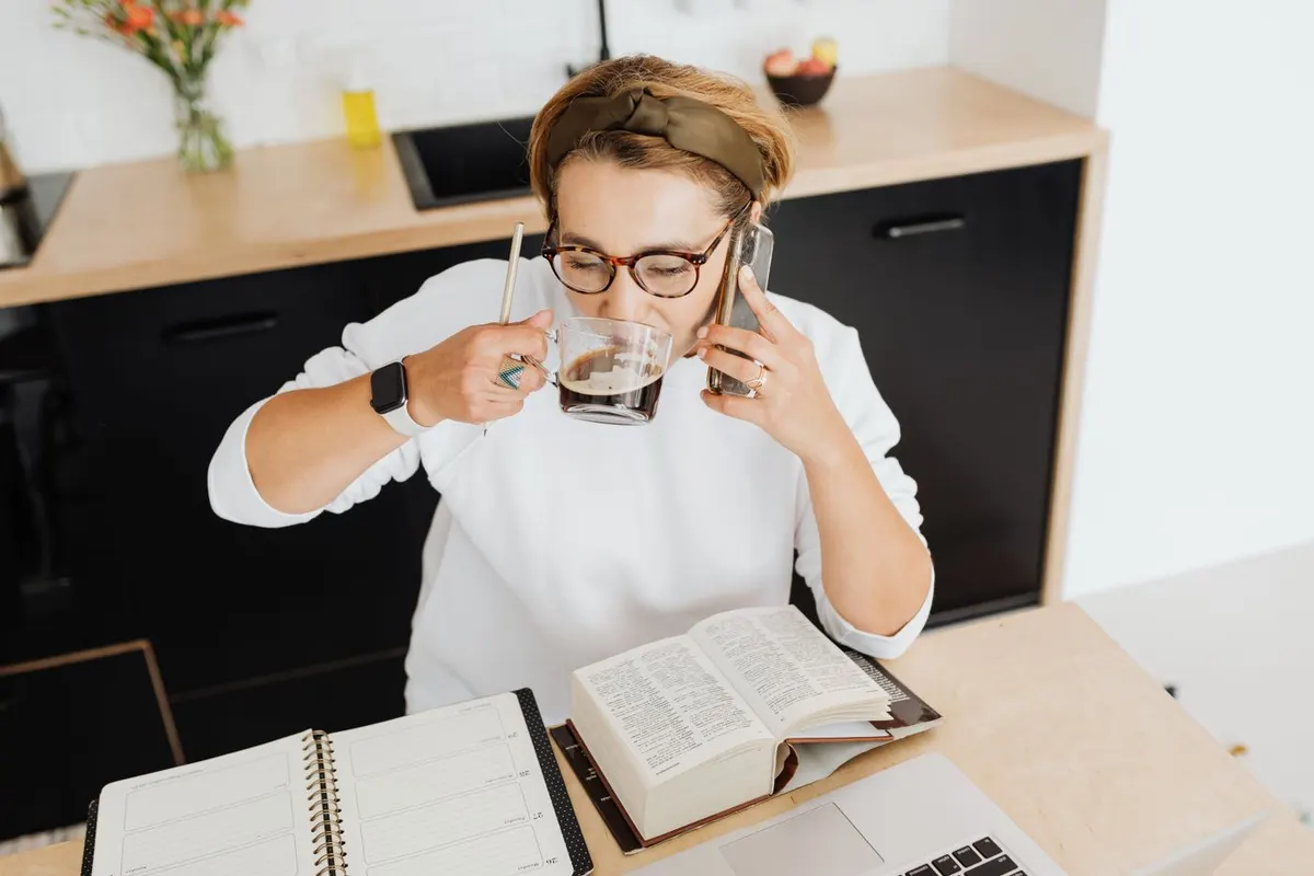 A woman in her forties on the phone at home, going through paperwork