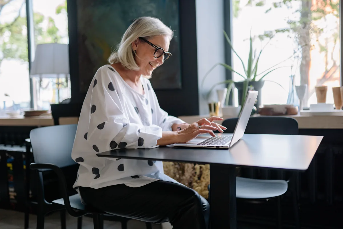 A woman using her laptop at a bright table