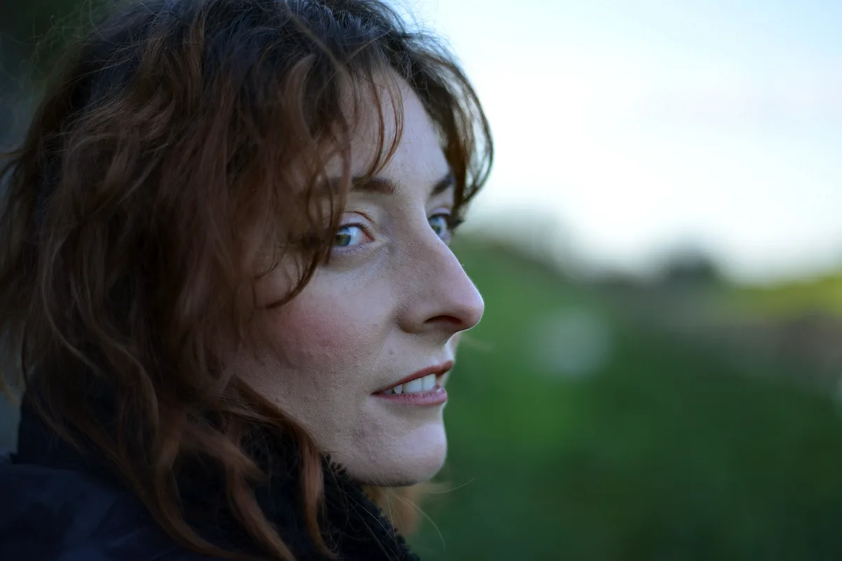 A woman sitting indoors, deep in thought
